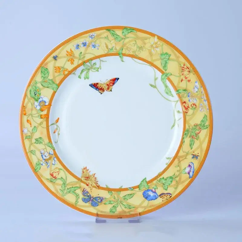 Decorative ceramic plate with vibrant yellow butterfly border and orange trim from floral turquoise and gold bone dinnerware set