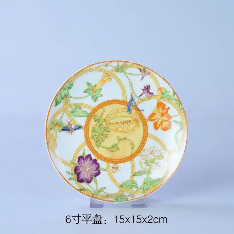 Decorative porcelain saucer from floral turquoise and gold bone dinnerware set featuring vibrant floral and insect design
