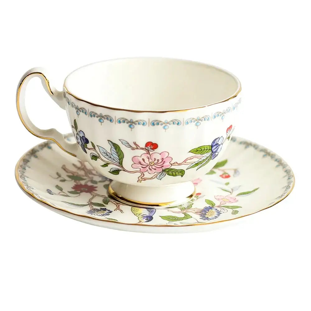 Delicate floral white bone china tea cup set with gold rim on ivory background for elegant dining room drinkware