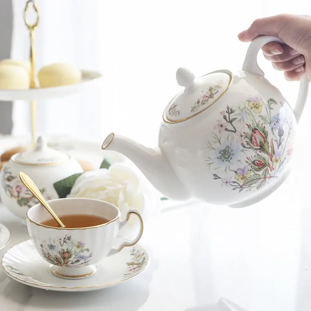 A delicate white bone tea set with intricate floral patterns and gold trim enhancing the tea-drinking experience