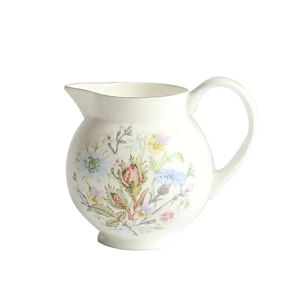 A delicate white bone china ceramic pitcher with hand-painted pastel floral pattern for tea set dining tableware