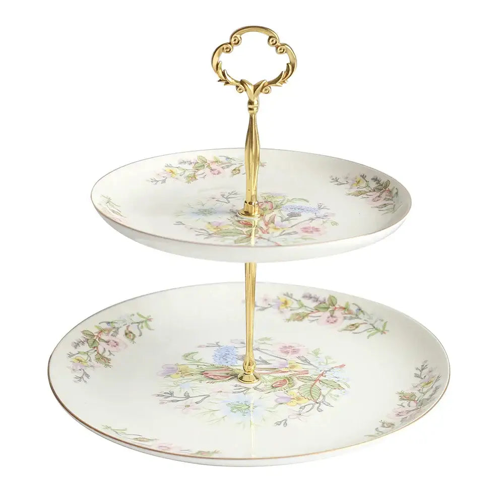 A delicate two-tiered floral white bone china tea set tray with ornate gold-toned handles enhances the tea-drinking experience