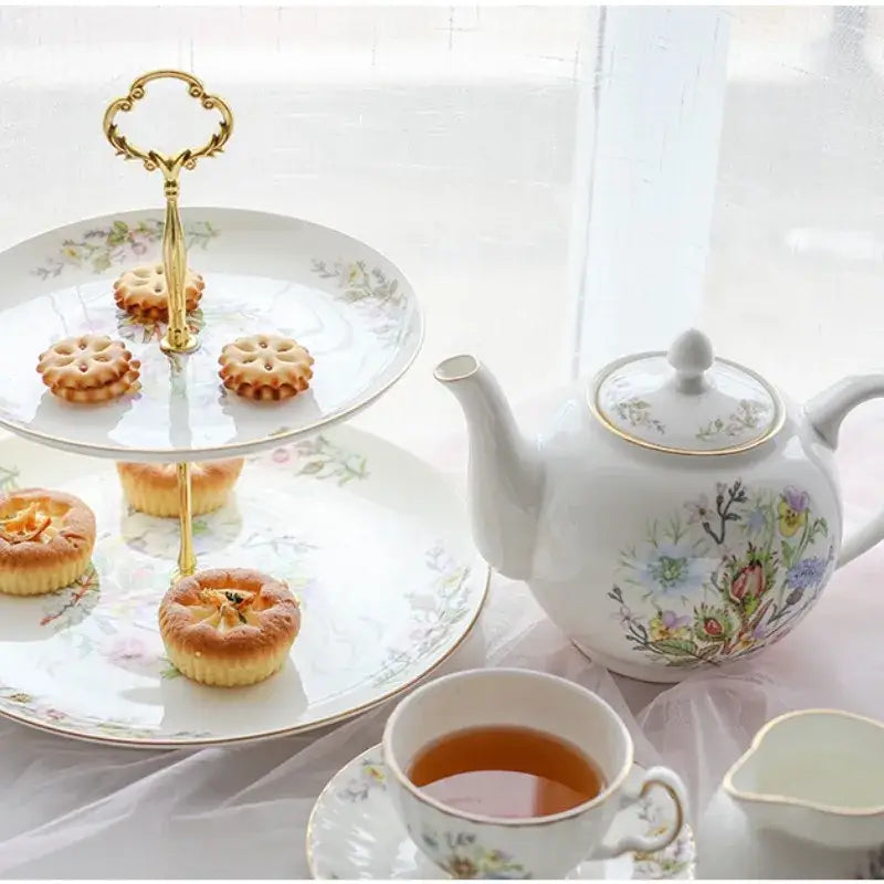 Gold-handled two-tiered serving tray with floral-patterned white bone china plates for an elegant tea set experience