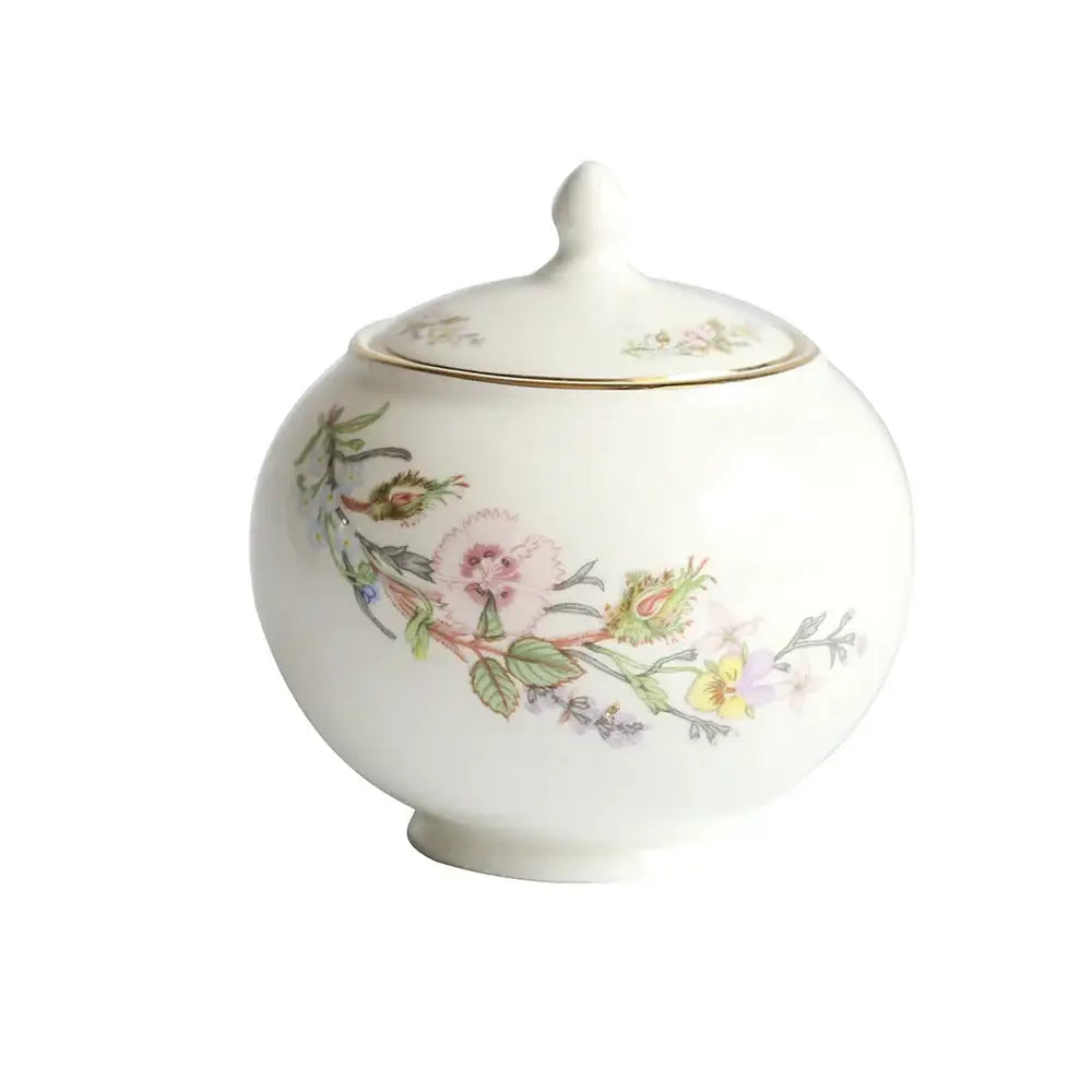 White porcelain sugar bowl with delicate floral design and gold rim from a floral white bone tea set for tea-drinking experience