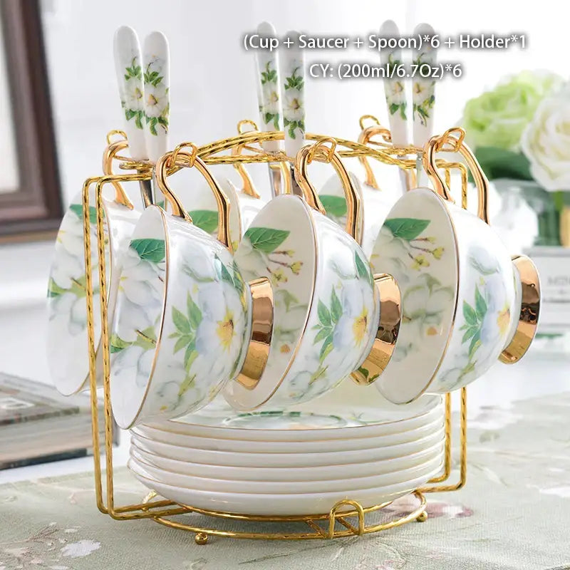 White porcelain teacups with gold rims and green floral decorbites camellia bone china in elegant gold holder