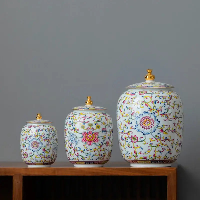 Three ornate floral white enamelled porcelain tea caddy ginger jars with gold lids for dining room display