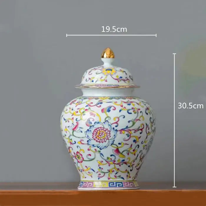 A white enamelled porcelain tea caddy ginger jar with multicolored floral patterns and a gold-tipped lid for dining room use
