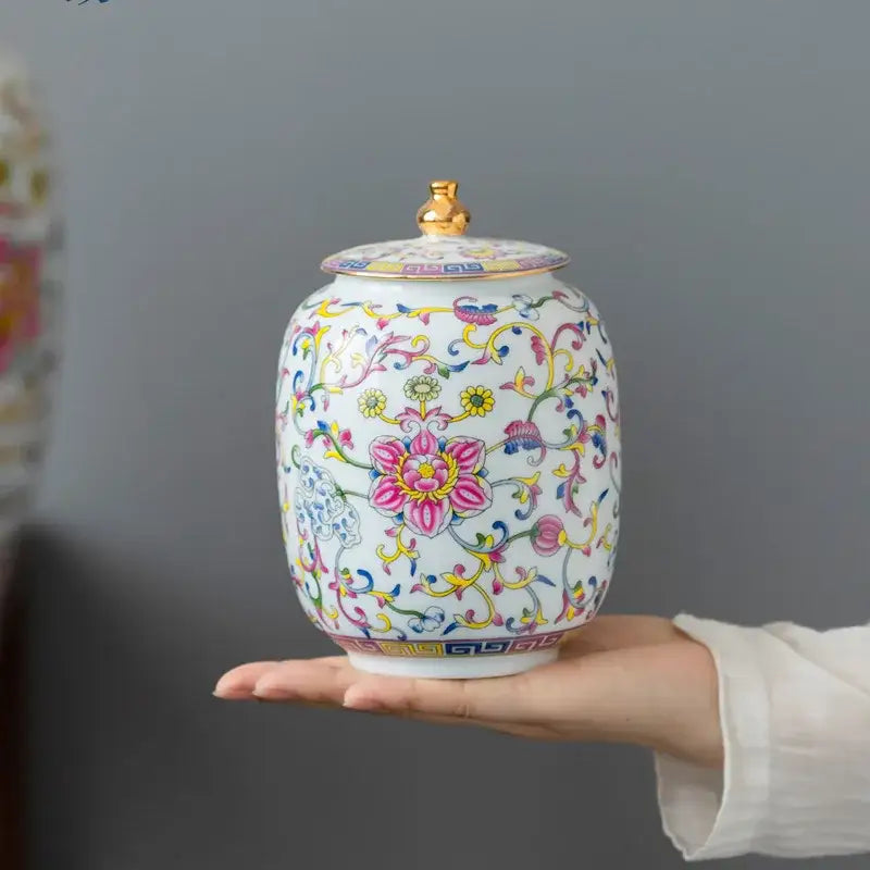 Floral white enamelled porcelain tea caddy ginger jar with gold lid knob and vibrant pink yellow blue floral patterns