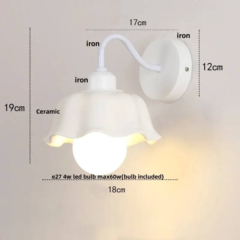 White ceramic wall sconce with fluted flower-like shade and iron mounting bracket from decorbites glass iron led collection