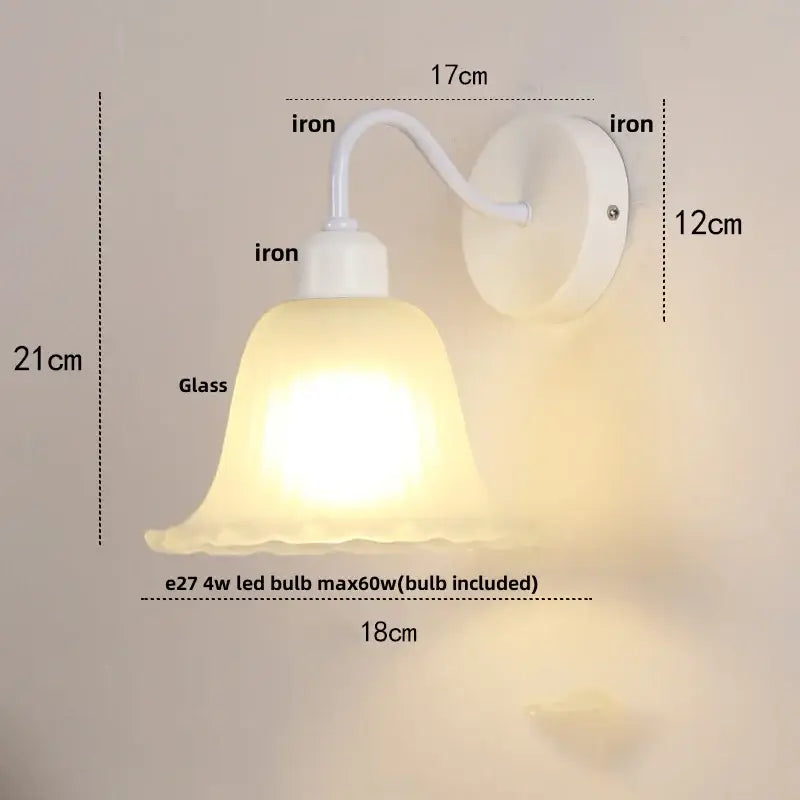 Floral white glass wall sconce with frosted bell-shaped shade and pull chain switch for stair lighting use