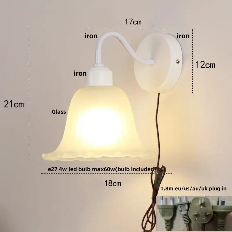 White iron wall sconce with frosted glass bell-shaped shade and pull chain switch for stair lighting