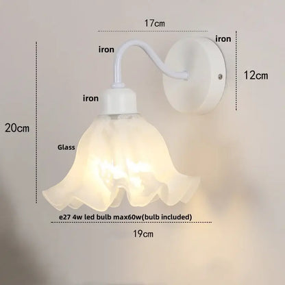 Floral white iron wall sconce with translucent ruffled glass shade and pull chain switch for stair light use