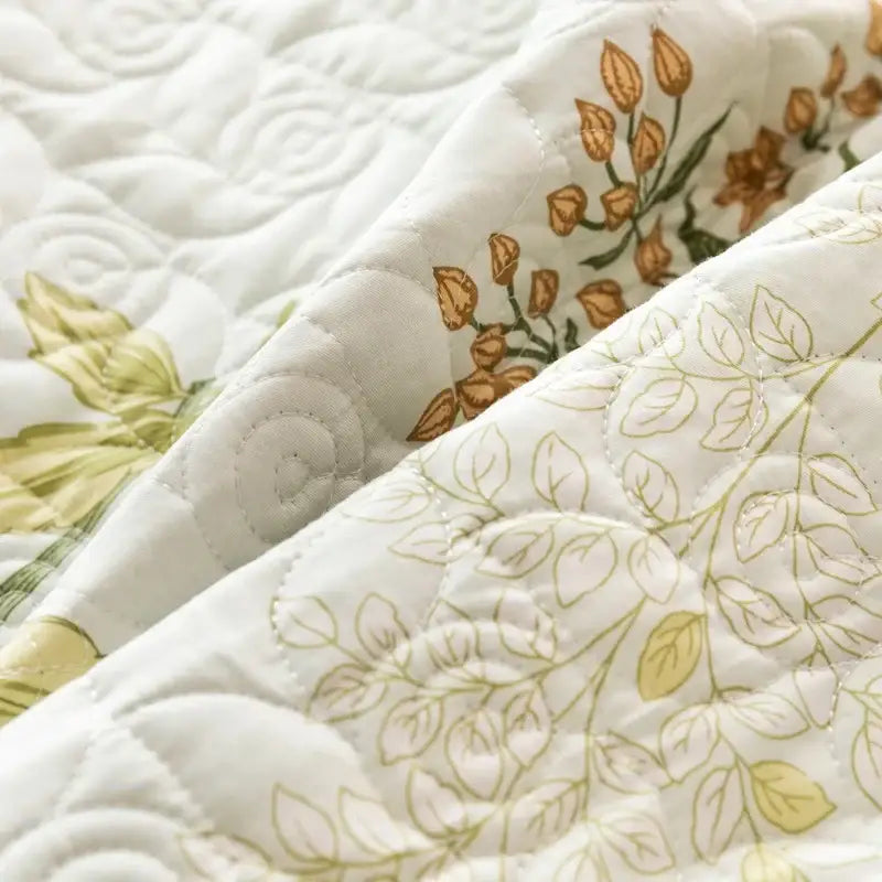 Floral white and green quilted cotton bed cover set with delicate gold and olive floral patterns and stitched texture