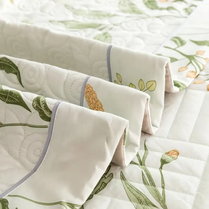 Floral white and green quilted cotton bed cover set with cream color and botanical prints featuring lavender trim
