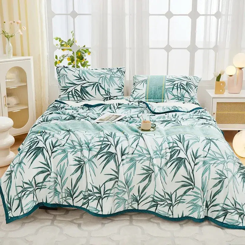 A floral white and navy cozy flannel plush blanket with a soft white duvet cover featuring green bamboo leaves and teal trim