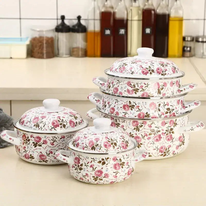 Set of four white and pink floral enamel ceramics soup saucepans with lids and silver rims for kitchen use