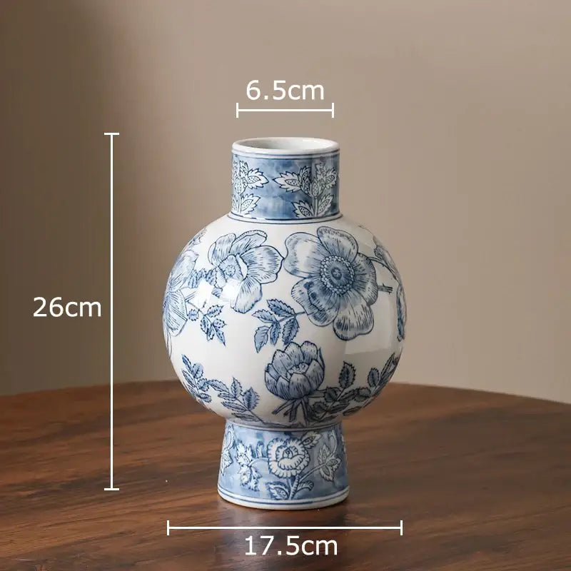 White porcelain vase with blue floral patterns, rounded body, and flared neck for living room decor