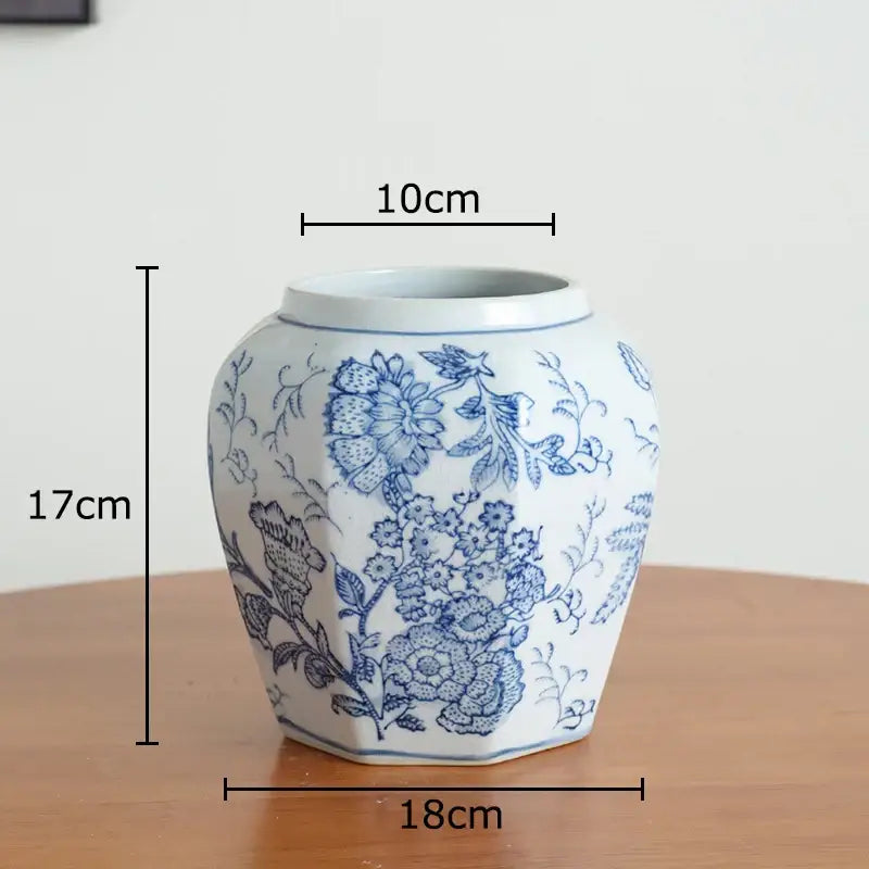 A white porcelain vase with intricate blue floral patterns and a hexagonal shape for living room decor
