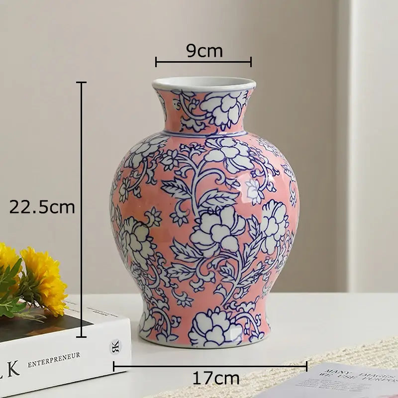 A pink porcelain vase with white porcelain interior and intricate blue floral patterns for living room decor