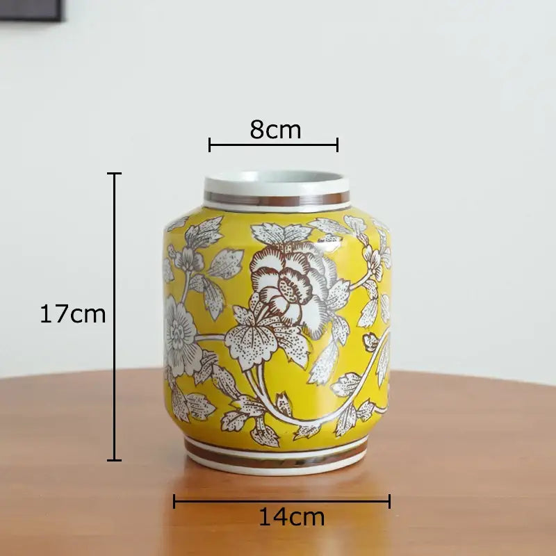 A vibrant yellow floral white porcelain vase with intricate patterns and gold-trimmed rim for living room decor
