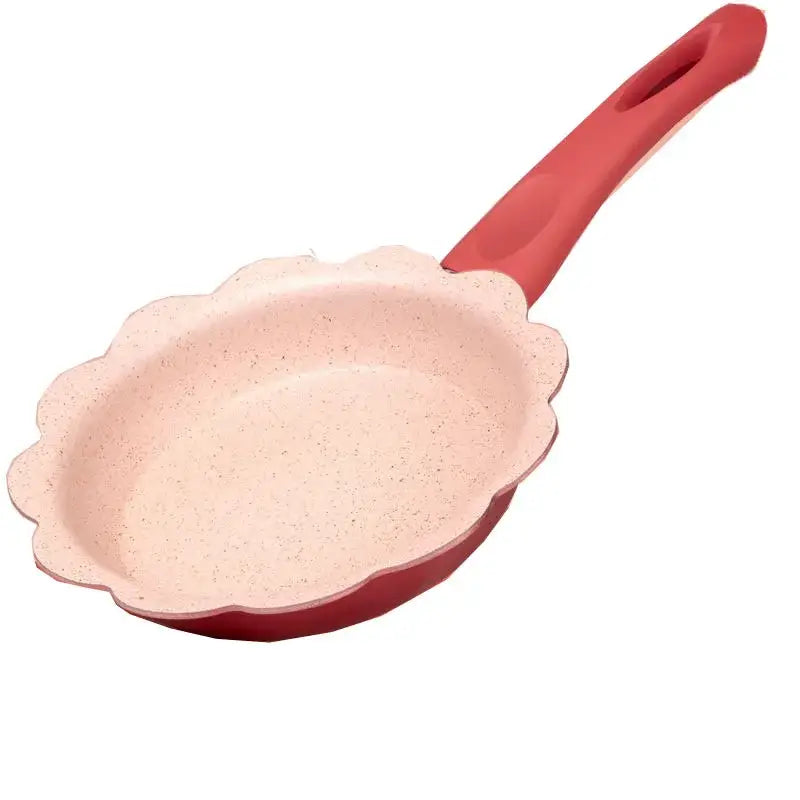 Pink speckled non-stick baby food pot with red scalloped edge and handle from flower edged kitchen cookware set