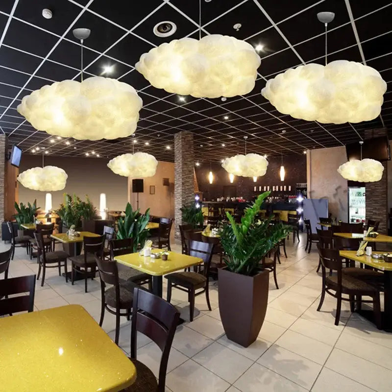 Soft glowing white cloud ceiling chandelier pendant lights hanging from a dark ceiling grid for bedroom use
