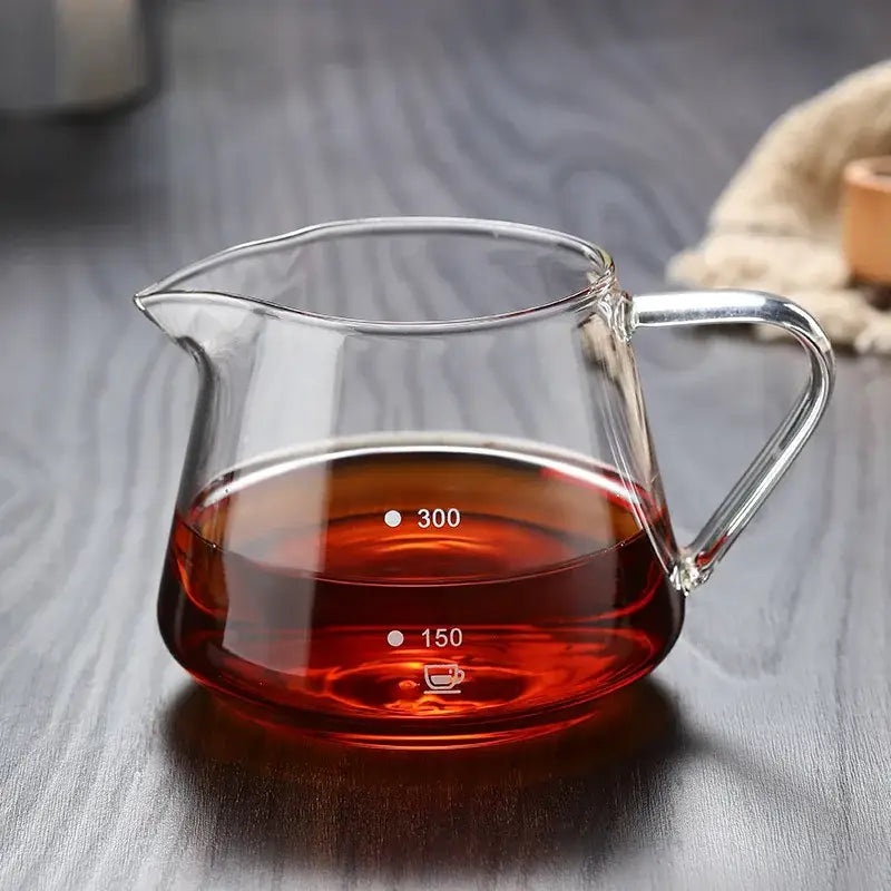 Fluted clear glass coffee pot with ribbed design and measurement markings filled with rich amber glass coffee