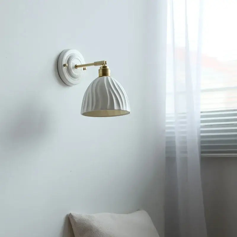 Fluted cream ceramic wall lamp with brass accents featuring vertical ridges, ideal as a decorbites ceramic wall light