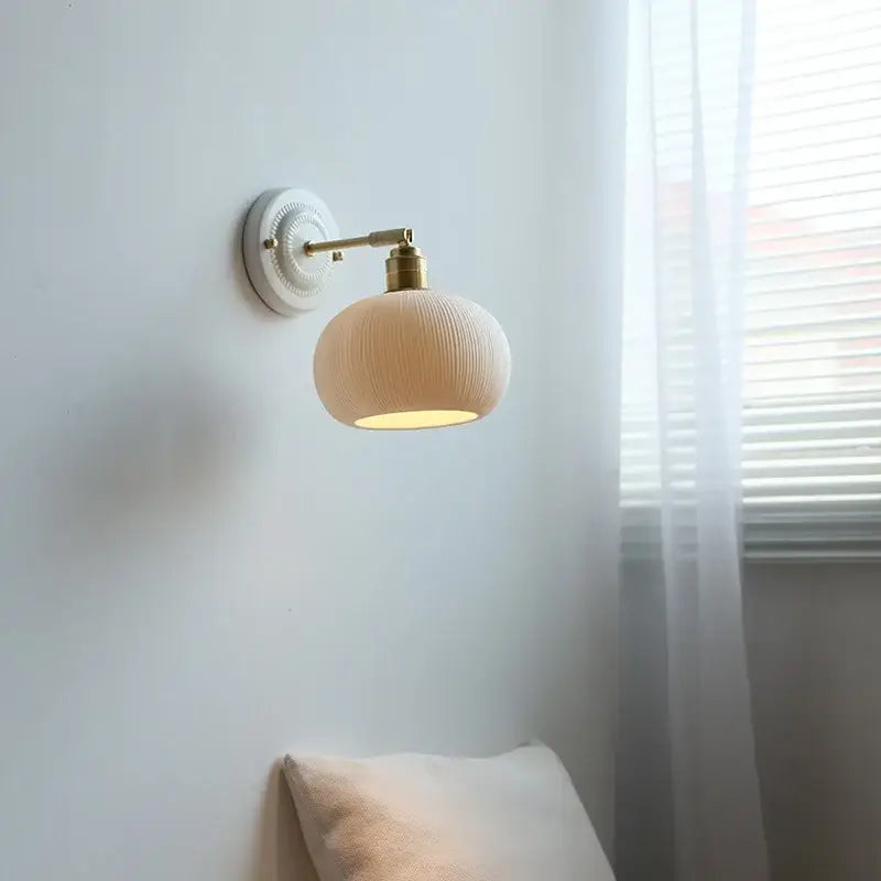 Fluted cream decorbites ceramic wall lamp with ribbed texture and brass accents for elegant bathroom lighting