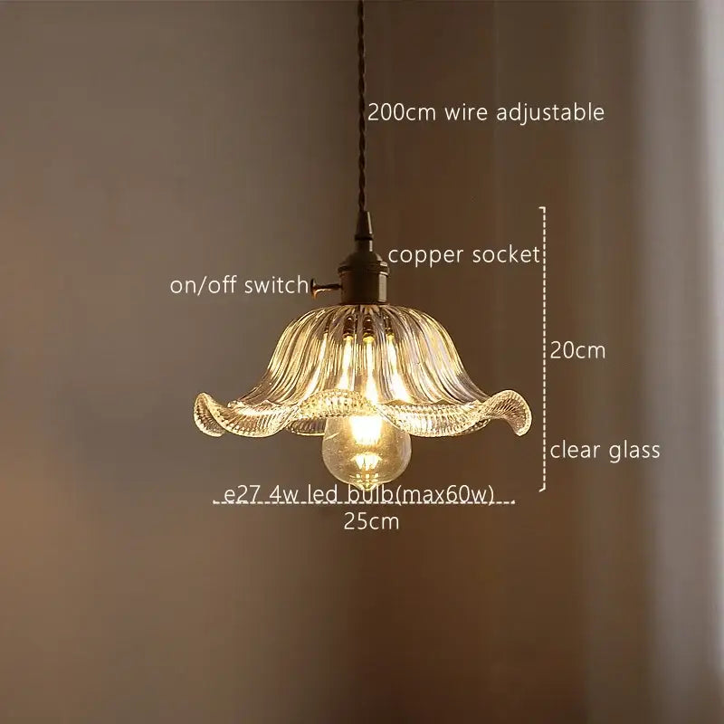 A delicate clear glass pendant light with a fluted petal-like design featuring decorbites green stripe glass