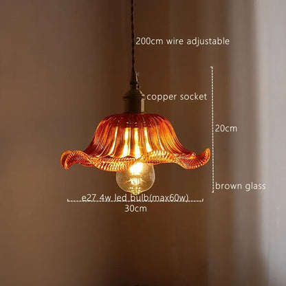 A warm amber-colored hand-blown glass pendant light with fluted petals and copper socket for decorbites green stripe glass decor