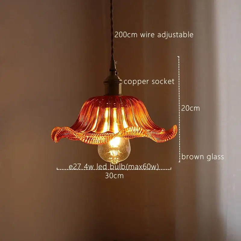 A warm amber-colored hand-blown glass pendant light with fluted petals and copper socket for decorbites green stripe glass decor