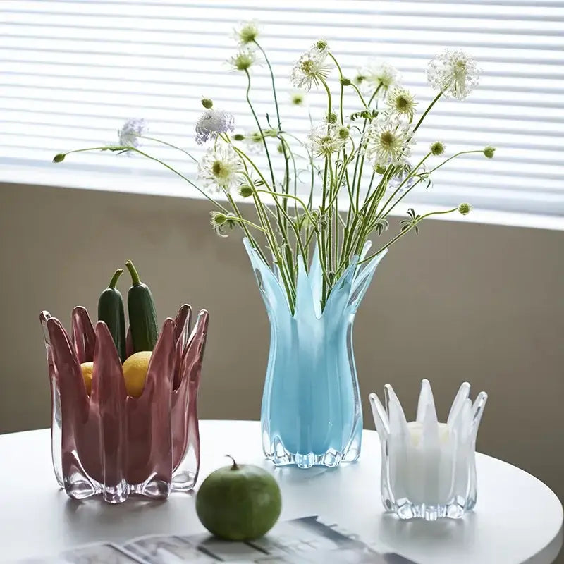 A translucent light blue geometric bud glass vase with fluted crown design holding white and green flowers decorbites decor