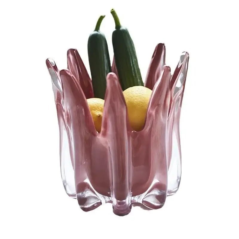 A translucent pink glass fruit bowl with a sculpted petal design complementing decorbites geometric bud glass vase decor