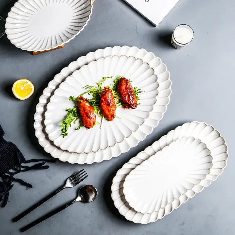 White ceramic dinnerware set with scalloped fan-like edges and gold trim featuring decorbites ceramic white glaze