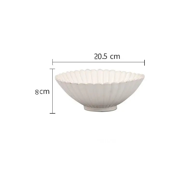 A white ceramic bowl with fluted scalloped rim and ceramic white glaze from decorbites dinnerware set with gold trim