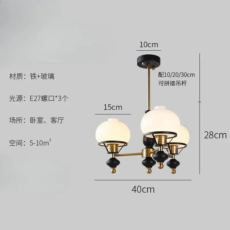 A decorbites French Bauhaus ceiling chandelier with black and brass metal frame and three frosted glass globe shades