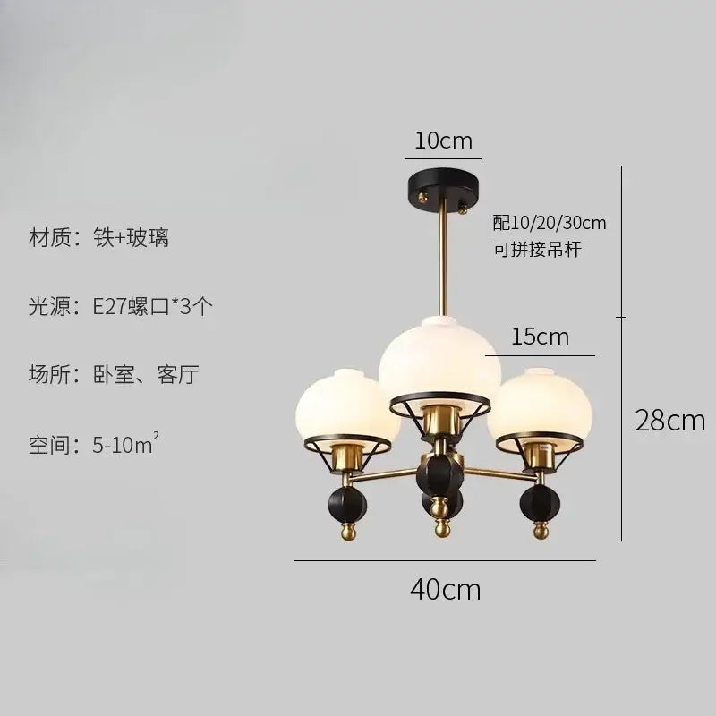 A modern french bauhaus ceiling chandelier with brass and black metal frame and frosted glass globes by decorbites