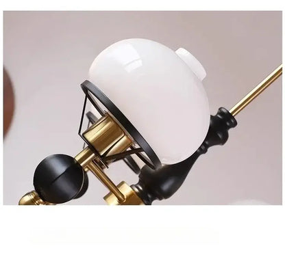 White opaline glass globe suspended from brass and black wrought iron arm in french bauhaus ceiling chandelier decorbites
