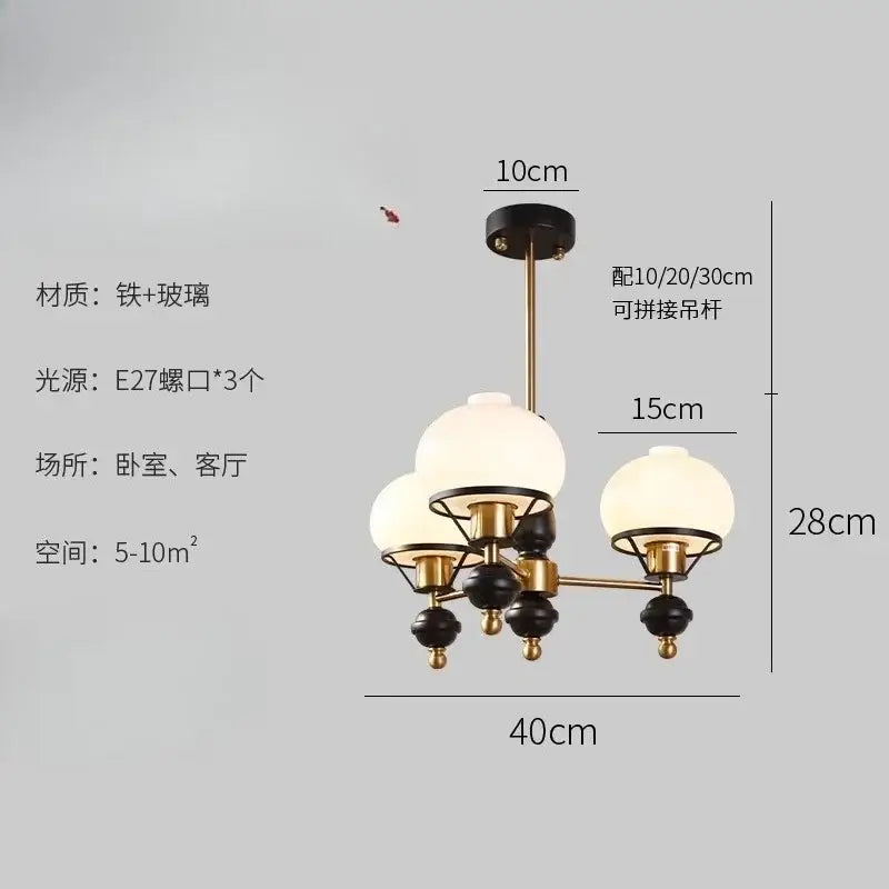 A french bauhaus ceiling chandelier with brass and black finish featuring three frosted glass globe shades by decorbites