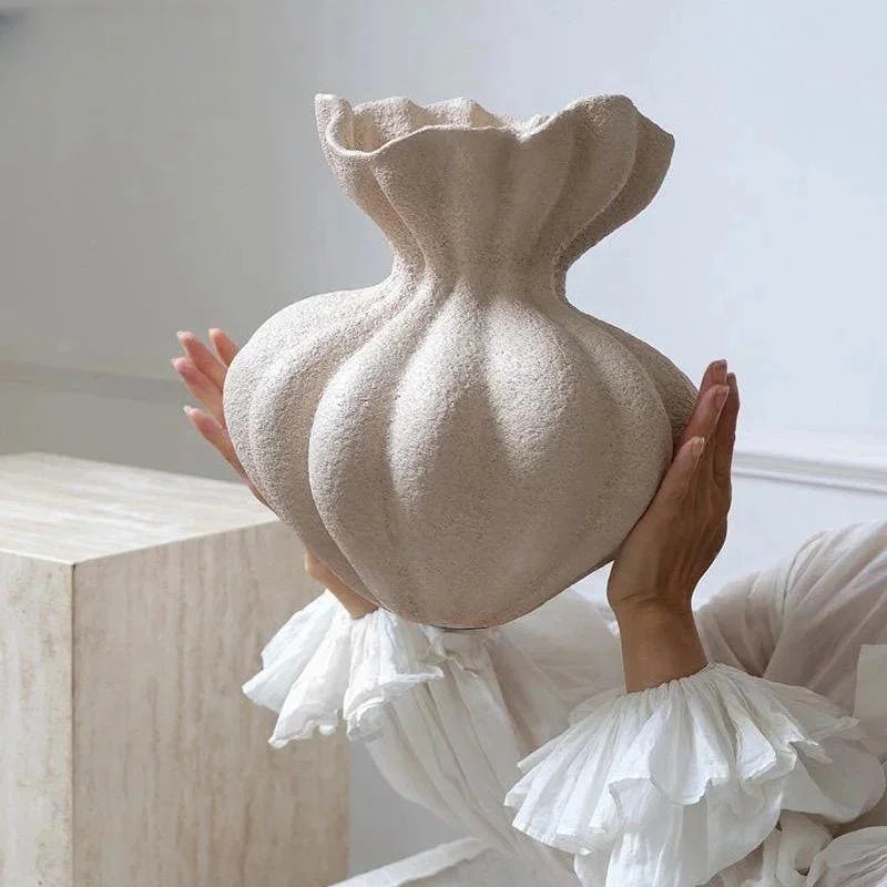 A textured off-white ceramic vase with a ruffled top and bulbous body for minimalist floral table decor