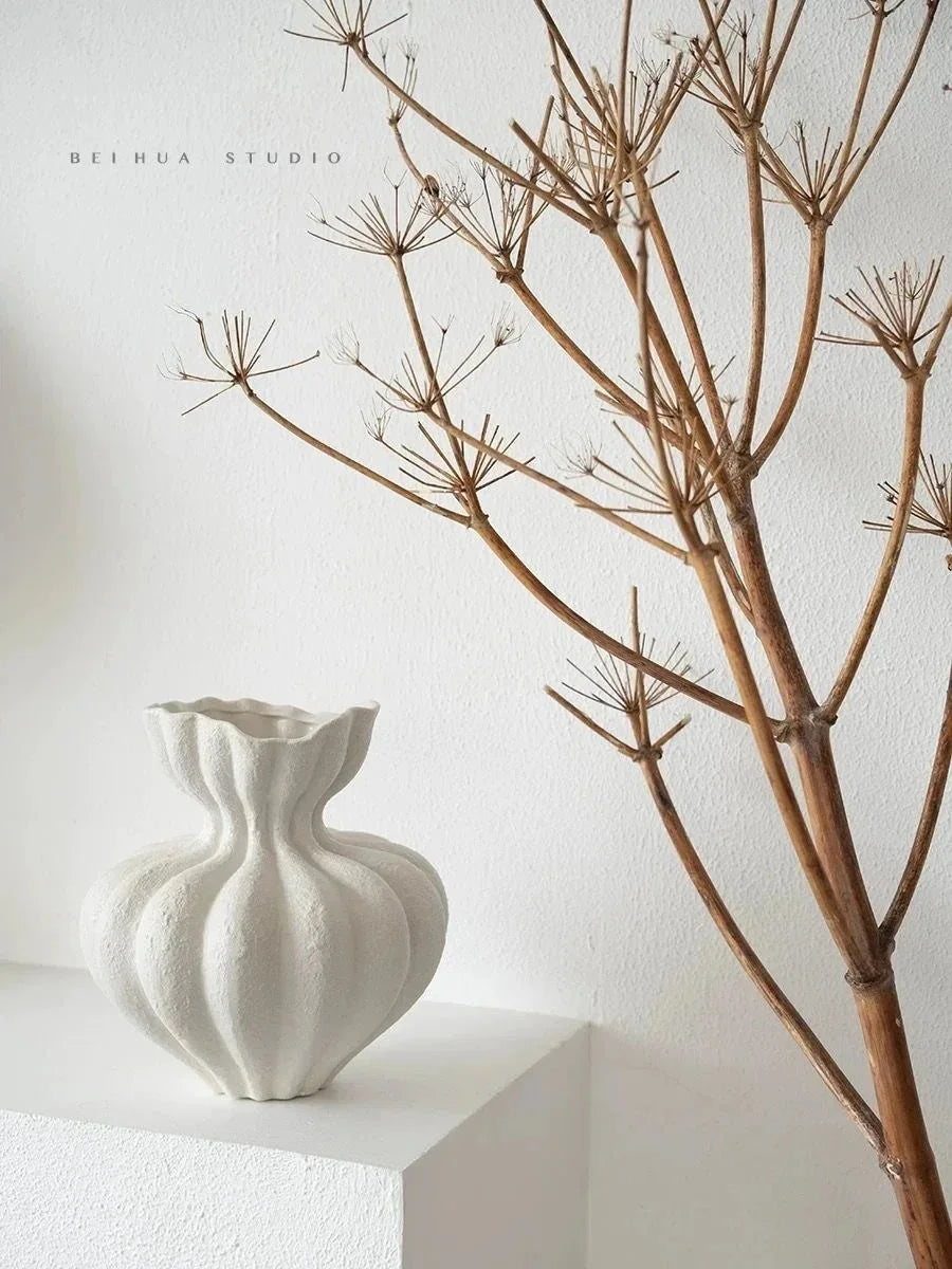 A white ceramic vase with fluted ribbed texture and organic shape for minimalist floral table centerpiece decor
