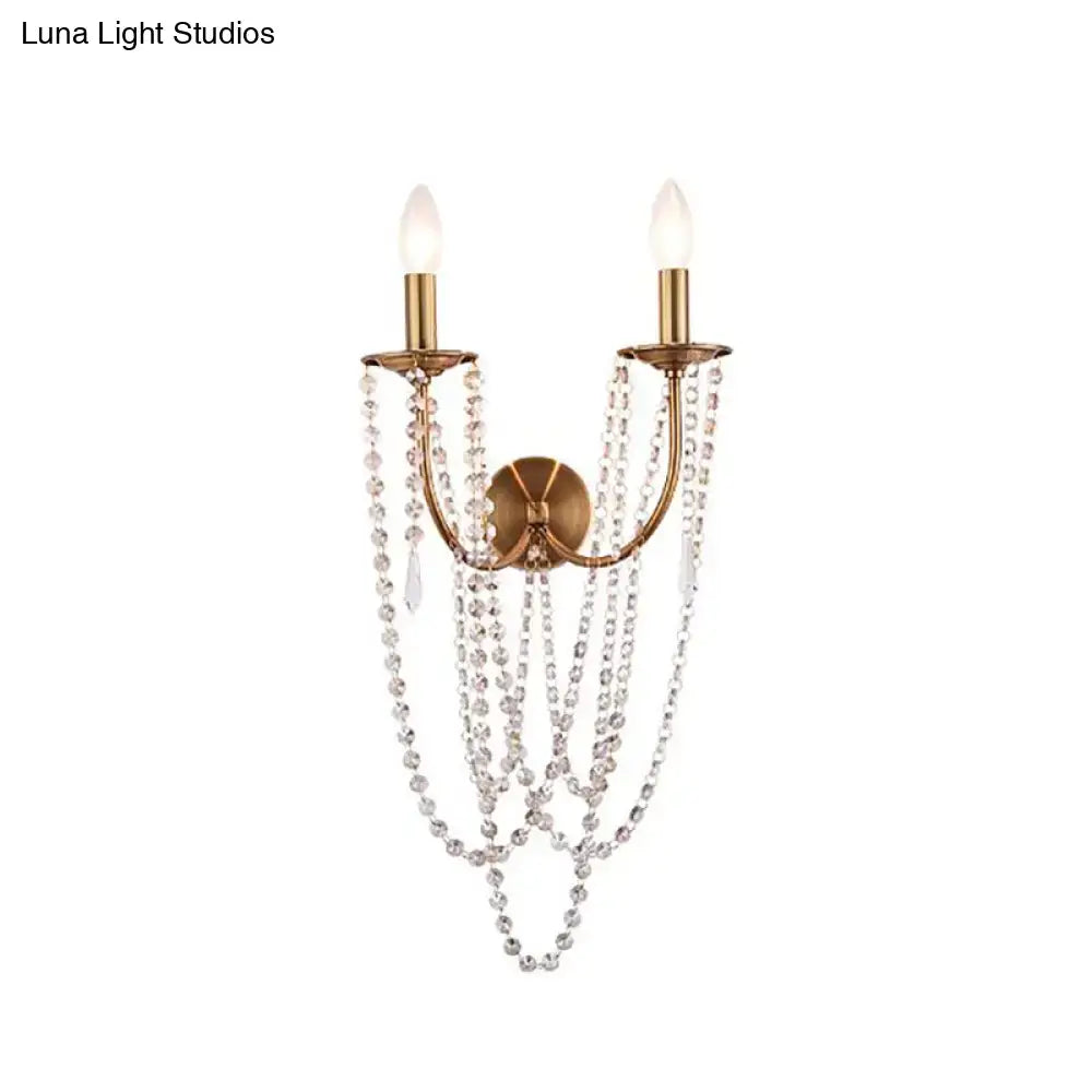 Antique brass two-light wall lamp with brushed brass finish and clear crystal bead strands for bedroom sconce lighting