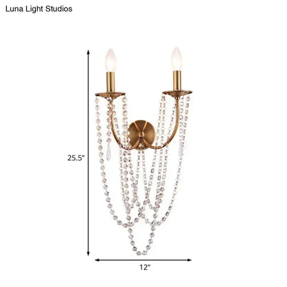Antique brushed brass wall lamp featuring two lights with cascading clear crystal beads for bedroom use
