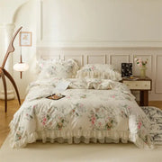 Cream-colored cotton bedding set with ruffled edges and pastel pink green beige blossoms for French country flowers decorbites