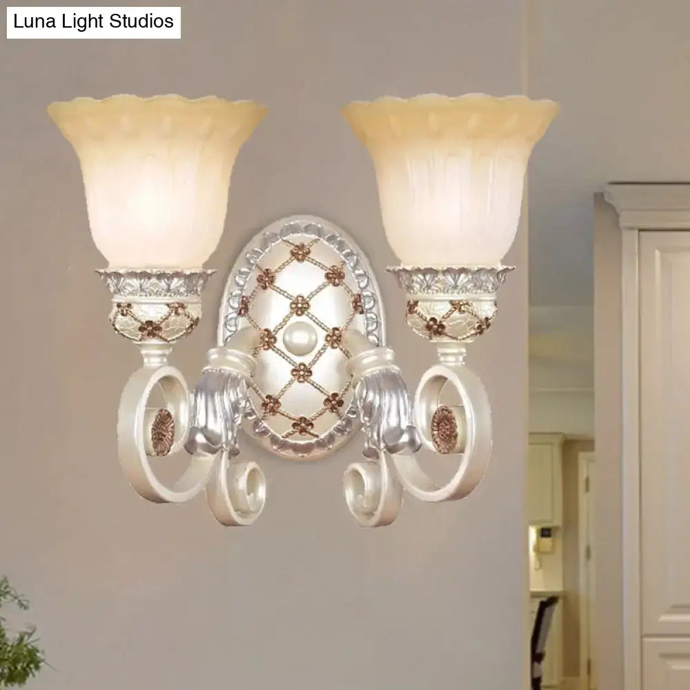 Elegant silver wall sconce with two frosted cream opaline glass shades and ornate floral detailing for living room