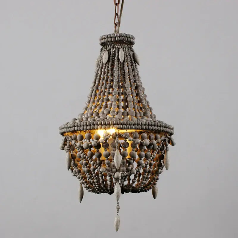 Rustic gray french country wood bead chandelier with warm glowing light for bedroom or dining room use