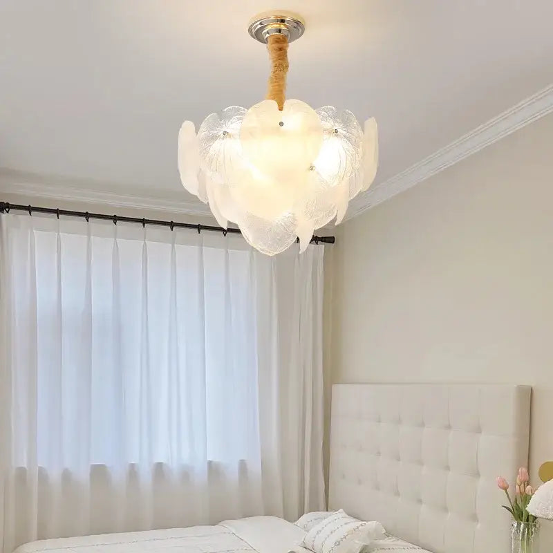 A delicate decorbites French cream crystal chandelier with white petal glass, wooden stem, and metallic fixture for living room decor