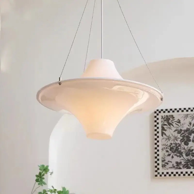 A cream modern chandelier featuring a white ceramic pendant with a sleek flared design and thin metal chains for dining rooms decorbites french cream