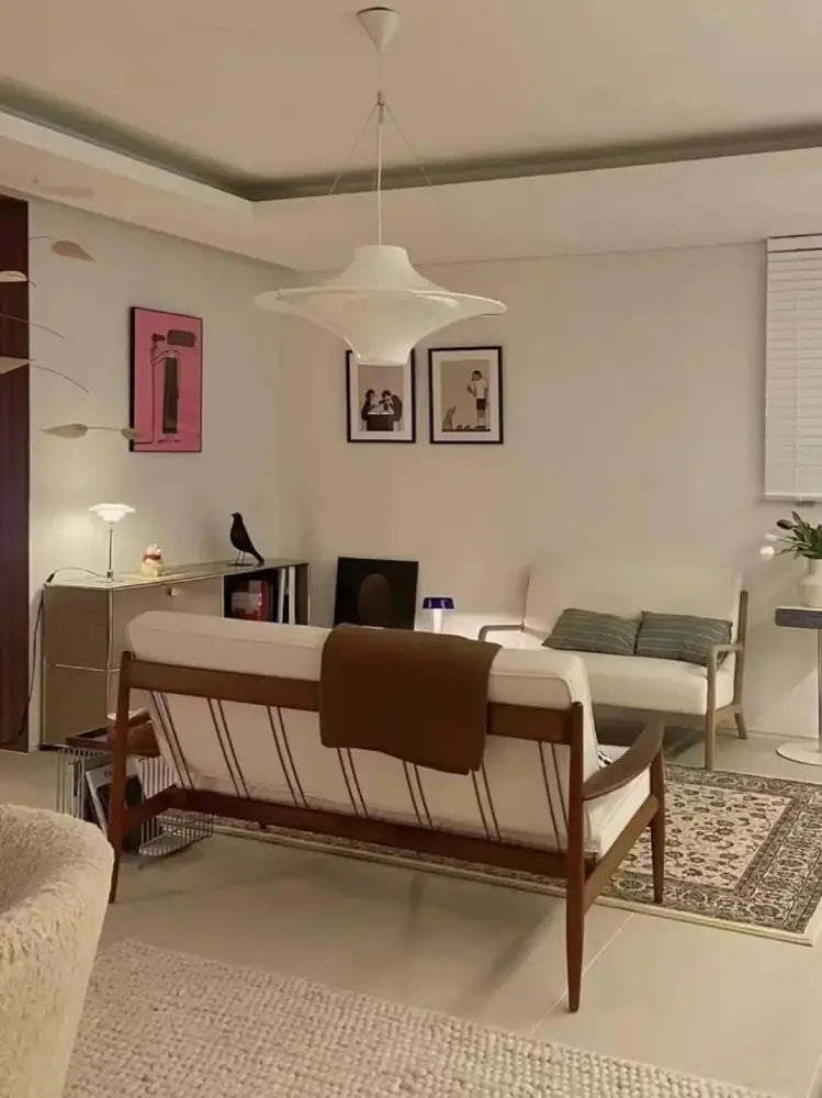 Mid-century modern wooden sofa with white upholstery and brown throw blanket paired with decorbites french cream modern white ceramic chandelier for dining room